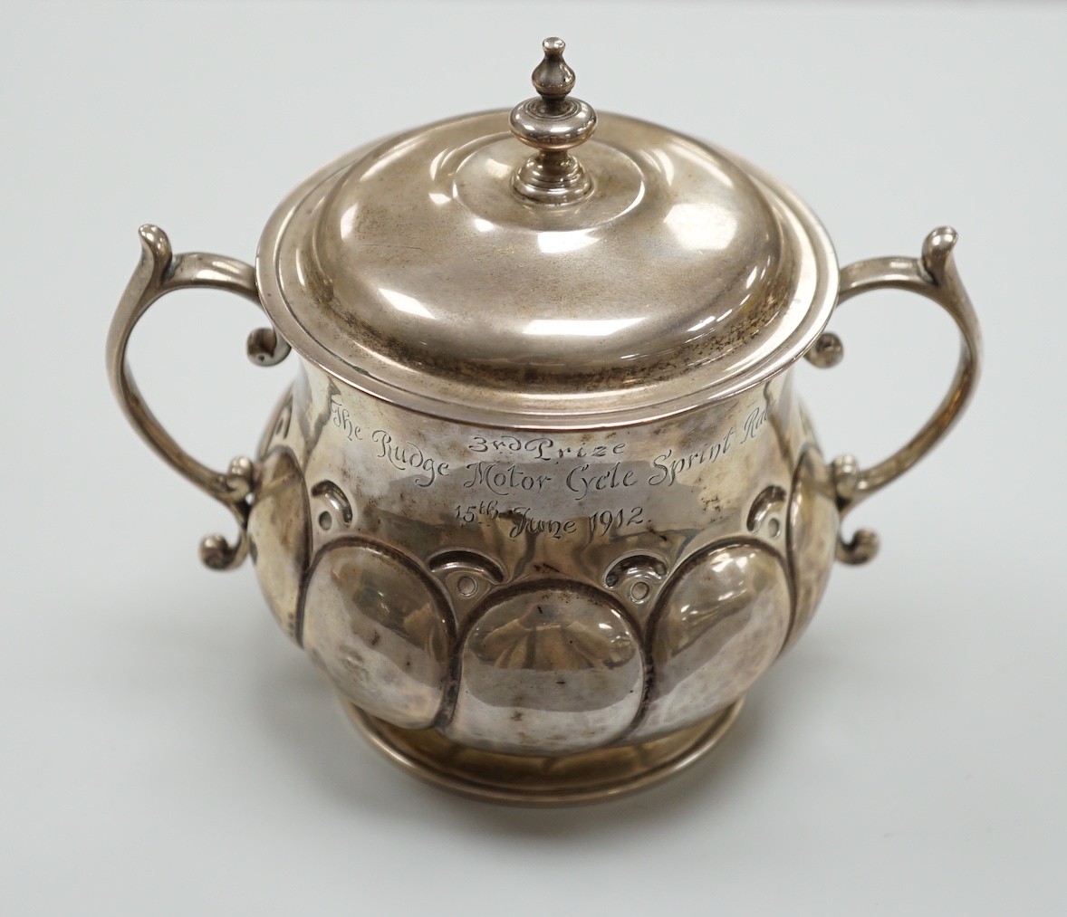 A George V silver presentation porringer and cover for the 'Rudge Motorcycle Sprint Race at Brooklands 13th of June 1912, third prize' William Comyns, height 10.5cm, 6.1oz.